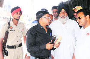 Independent candidate Bal Krishan Sharma shows his symbol battery torch to people during campaigning in Amritsar on Wednesday.