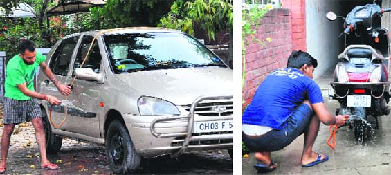 Giving the ban the go-by, residents wash their vehicles in Sector 20, Chandigarh, on Wednesday. Tribune photos: Parvesh Chauhan