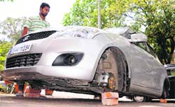 Thieves took away the tyres of a car in Sector 15, Chandigarh, on Wednesday. Tribune photo: Manoj Mahajan
