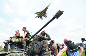 A fighter jet flies above as Ukrainian soldiers sit on an armoured carrier in Kramatorsk in eastern Ukraine on Wednesday.