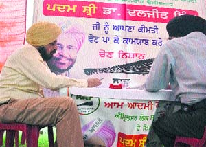 The snapshot of Dr Gurpreet Singh (left) shows him sitting on the table with publicity material of AAP candidate Dr Daljit Singh in Amritsar. 