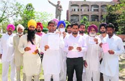 Parents show receipts of books bought by them for their children outside the District Administrative Complex in Bathinda on Thursday. tribune photo: Pawan Sharma 