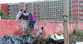 Residents of Sector 25 scale the boundary wall of girls hostel number 9 at Panjab University in Chandigarh.