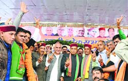 BJP leaders make victory signs at a rally in Mandi on Thursday.