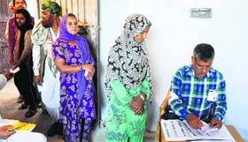 Voters wait for their turn to cast vote at a polling booth at Keerian Gandyal village.