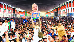 A BJP supporter holds a cutout of the partys PM candidate Narendra Modi during a rally. 