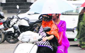 Girls try to protect themselves from showers in Amritsar on Friday.