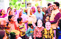 BJP candidate Anurag Thakur interacts with women voters and children at the Kutlehar Assembly segment in Una on Friday.