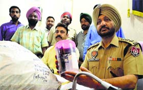 A policeman shows a pistol that was recovered from the trio in Ludhiana. 