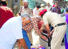 A cop checks the bag of a passenger at the city railway station in Amritsar on Saturday
