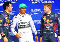 Mercedes Lewis Hamilton (centre) celebrates with second-fastest Red Bulls Daniel Ricciardo (left) and third-fastest Sebastian Vettel after taking pole position on Saturday. Reuters