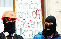 Masked pro-Russian protesters stand guard outside a regional government building in Donetsk on Saturday