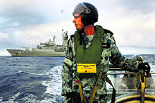 An armyman looks for debris of the missing Malaysian Airlines flight MH 370 in the southern Indian Ocean
