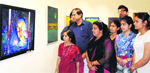 Visitors at a painting exhibition organised for Jammu and Kashmir artists at an art gallery in Amritsar on Sunday.