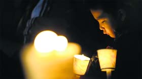 A child takes part in a candlelight vigil for missing passengers, at a park in Ansan on Sunday.