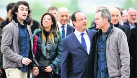Journalists Didier Francois (R) and Edouard Elias (L) walk with French President Francois Hollande (2ndR) moments after their arrival at Villacoublay military airbase, near Paris, on Sunday.