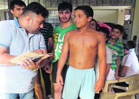 Weight issue: An organiser checks the weight of a wrestler during the selection process at the Sector 42 stadium in Chandigarh on Monday