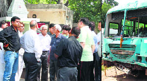 Relatives of Dr Pankaj Gupta outside mortuary, and (right) the bus that hit the doctor and his daughter in Gurgaon on Monday.