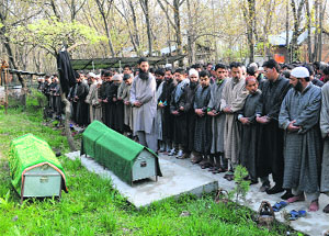 People attend the funeral prayers of Congress sarpanch Ghulam Nabi Mir and his son Firdous Ahmad Mir of Batigund village in Pulwama district on Tuesday.