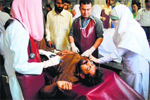 Hospital staff treat a blast victim in Peshawar on Tuesday