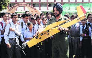 An official shows the model of an aeroplane during an awareness rally of the Chandigarh Air Wing NCC unit at DAV School, Sector 8, in Chandigarh on Wednesday.