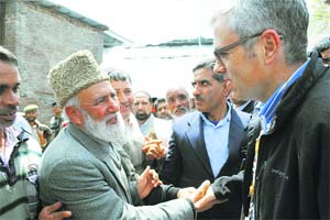Chief Minister Omar Abdullah shakes hands with a National Conference leader during a rally in Ganderbal district on Wednesday.