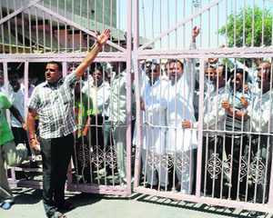 Angry traders lock the main gate of the grain market in Fatehabad on Thursday.