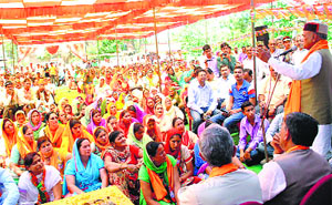 BJP leader PK Dhumal addresses an election meeting at Lamblu in Hamirpur on Thursday. 