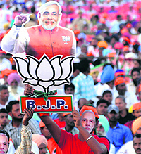 A BJP supporter waves a picture of Narendra Modi during a rally in Amritsar on Friday