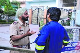 A resident of Model Town Phase-III argues with a police official as he was not being allowed to enter his house