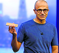 Microsoft CEO Satya Nadella holds a Nokia Lumia mobile phone at the company's "build" conference in San Francisco in this file photo. Nokia on Friday announced that the sale of its once-dominant handset business to Microsoft has been closed