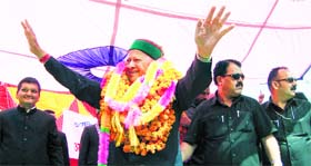 Chief Minister Virbhadra Singh waves at a crowd before addressing an election meeting at Janjehli in Mandi on Saturday.