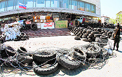 A masked pro-Russian activist stands by a barricade outside the regional state building seized by the separatists in the eastern Ukrainian city of Donetsk on Saturday