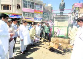 State Congress spokesperson Hoshiari Lal Sharma and party workers burn effigy of yoga guru Ramdev in Sirsa on Sunday