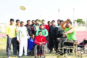 Sunil Phogat, a paraplegic youth of Bhalot village in Rohtak district, practises discus throw as his coach and fellow players watch