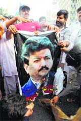 Supporters of the Pakistan Army burn a poster of Hamid Mir at a rally in Karachi.
