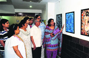 People have a look the paintings during an exhibition at KT Art Gallery in Amritsar on Monday.