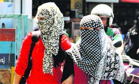 Girls covered in dupattas to save themselves from the heat wave in Dehradun on Monday.