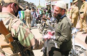 Policemen check motorcyclists ahead of the elections in Srinagar