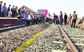 Protesters stop a train during protest at the Anantnag railway track in south Kashmir's Anantng district on Monday