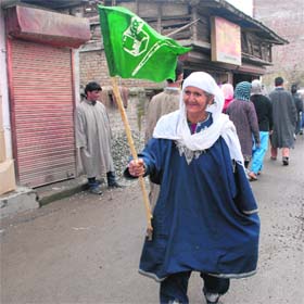 Staunch supporter: An elderly supporter of the PDP waves the party flag during a campaign rally at Natipora in Srinagar on Monday