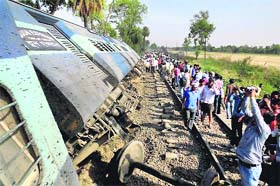 People gather at the accident site near the Jafarganj railway station in Ambedkar Nagar district of UP on Monday. The incident took place when eight coaches got detached from the main train and derailed near the railway station.