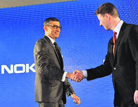 Newly appointed CEO of Nokia Rajeev Suri (L) shakes hands with Chairman of the Board of Directors Risto Siilasmaa in Espoo, Finland, on Tuesday.