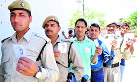 Policemen wait for their turn to cast votes at the Police Lines in Dehradun on Tuesday