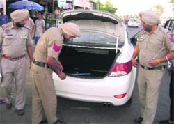 Policemen check a vehicle a day before elections at Dehlon on Tuesday. 