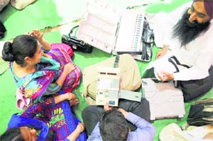 Government employees on election duty check electronic voting machines before leaving for their polling stations in Ludhiana on Tuesday. 