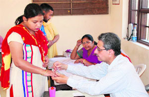 Polling officer marks the finger of a woman with indelible ink at a polling booth at Majitha on Wednesday.
