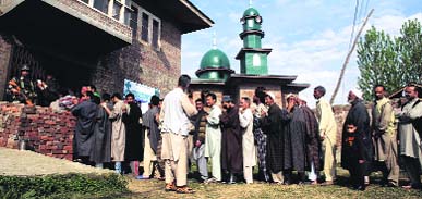 People wait in queue to cast their votes in Budgam district on Wednesday.