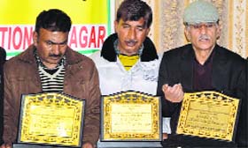 A file photo of the parents of slain youths Zahid Farooq, Wamiq Farooq and Tufail Matoo at a function in Srinagar.