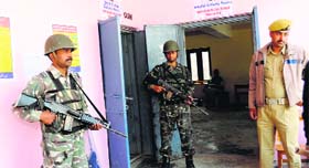 Security forces personnel stand guard at a polling station that wears a deserted look at Soura in Srinagar on Wednesday.